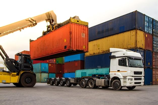 truck while loading in logistic shipping yard with cargo container forklift truck handling truck logistic import export concept loading and unloading of containers in the port premium photo